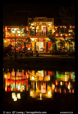 Waterfront house reflected in river at night. Hoi An, Vietnam