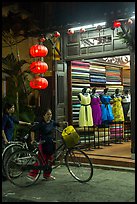 Women with bicycles in front of taylor shop. Hoi An, Vietnam (color)