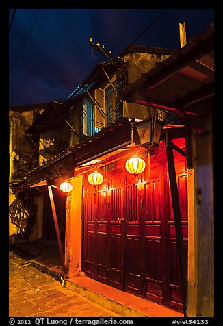 Townhouse with wooden doors lighted by paper lanterns. Hoi An, Vietnam