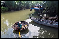 Man rows coracle boat in river channel. Hoi An, Vietnam ( color)