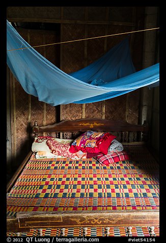 Wooden bed with straw mat and mosquito net, Cam Kim Village. Hoi An, Vietnam