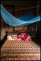 Wooden bed with straw mat and mosquito net, Cam Kim Village. Hoi An, Vietnam (color)