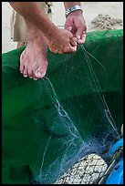 Close-up of hands and feet of man mending net. Da Nang, Vietnam ( color)