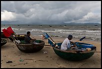 Fishermen mending nets in coracle boats. Da Nang, Vietnam (color)