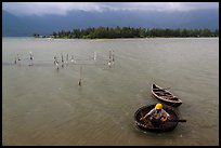 Man rowing coracle boat in lagoon. Vietnam ( color)