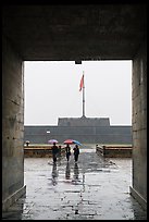 Tourists with unbrellas and flag monument, citadel. Hue, Vietnam (color)