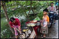 Boy waiting for donut coooked near canal, Thanh Toan. Hue, Vietnam (color)