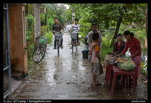 Canalside street with bicyclists and food stand, Thanh Toan. Hue, Vietnam (color)