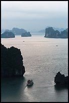 Tour boat navigating between islets. Halong Bay, Vietnam (color)