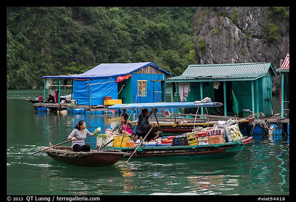 Woman buying produce from grocery boat, Vung Vieng village. Halong Bay, Vietnam (color)