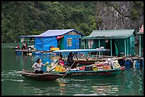 Woman buying produce from grocery boat, Vung Vieng village. Halong Bay, Vietnam (color)