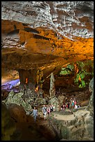 Tourists walking in cavernous chamber, Sungsot cave. Halong Bay, Vietnam (color)