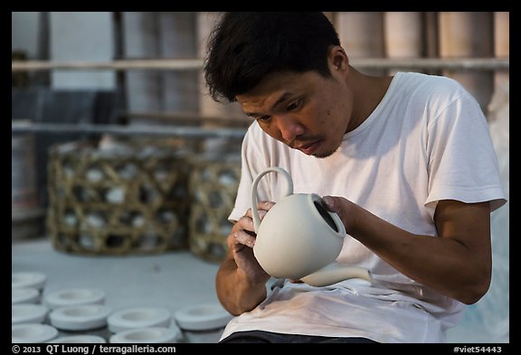 Man assembling ceramic tea pot in workshop. Bat Trang, Vietnam (color)