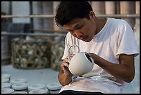 Man assembling ceramic tea pot in workshop. Bat Trang, Vietnam (color)