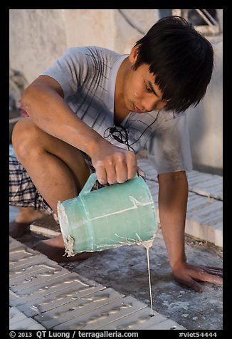 Man pouring clay into molds in ceramic workshop. Bat Trang, Vietnam