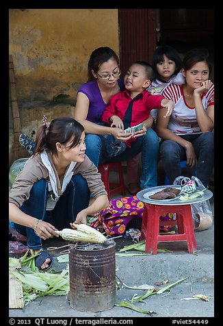 Woman roasting corn in the street. Bat Trang, Vietnam