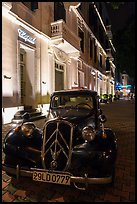 Vintage car in front of Metropole hotel at night. Hanoi, Vietnam (color)