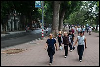 Numerous people walk counter-clockwise around Hoang Kiem Lake. Hanoi, Vietnam (color)