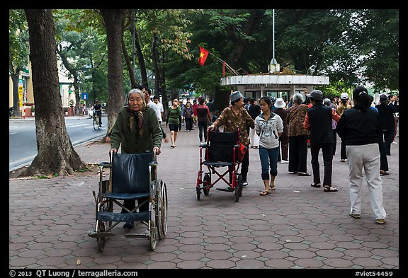 Elderly women pushing their wheelchairs while walking for exercise. Hanoi, Vietnam (color)