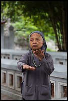 Elderly woman doing Tai Chi moves. Hanoi, Vietnam (color)