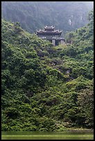 Temple perched on lush hill, Trang An. Ninh Binh,  Vietnam (color)