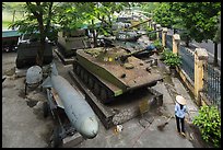 Woman sweeping floor in front of tanks, military museum. Hanoi, Vietnam ( color)