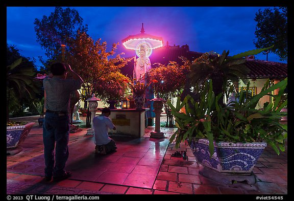 Men pray at outside Phung Son Pagoda at night, district 11. Ho Chi Minh City, Vietnam