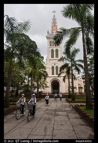 Students biking past Cho Quan Church, district 11. Ho Chi Minh City, Vietnam (color)