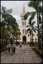 Students biking past Cho Quan Church, district 11. Ho Chi Minh City, Vietnam (color)