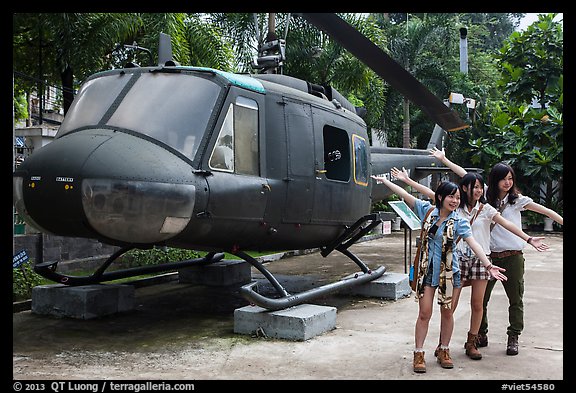 Young women posing with helicopter, War Remnants Museum, district 3. Ho Chi Minh City, Vietnam (color)