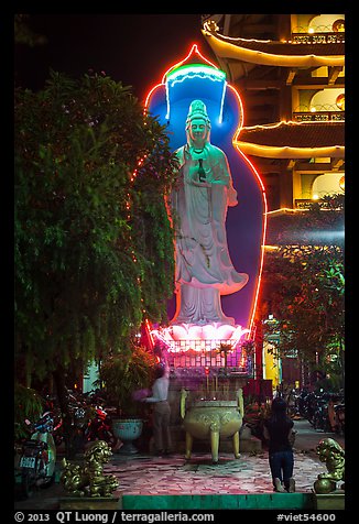 Praying outside Quoc Tu Pagoda at night, district 10. Ho Chi Minh City, Vietnam (color)