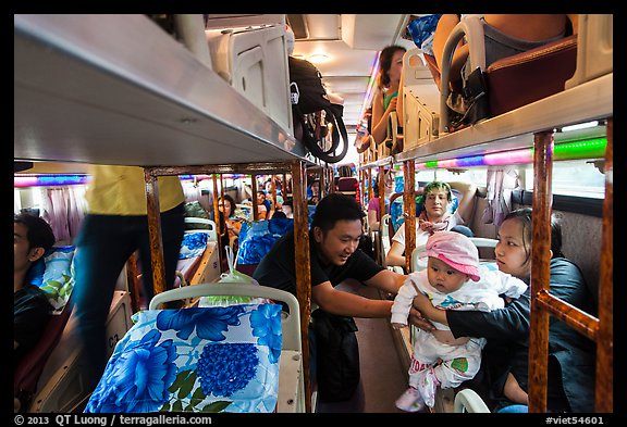 Couple passing baby on sleeper bus. Vietnam