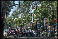 Motorcyclists on tree-lined street, district 5. Ho Chi Minh City, Vietnam