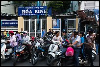 School entrance with parents waiting on motorbikes. Ho Chi Minh City, Vietnam