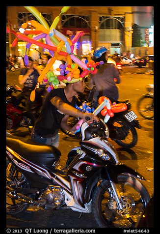 Man with coiffe of balloons, Christmas Eve. Ho Chi Minh City, Vietnam (color)