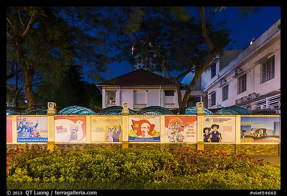 Fenced buildings with propaganda posters at night. Ho Chi Minh City, Vietnam