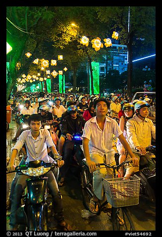Street packed with motorbikes and bicycle riders at night. Ho Chi Minh City, Vietnam (color)