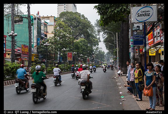 Motorbike traffic and pedestrians waiting for bus. Ho Chi Minh City, Vietnam (color)