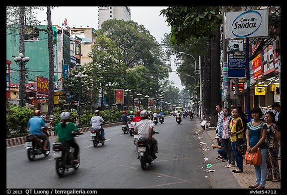 Motorbike traffic and pedestrians waiting for bus. Ho Chi Minh City, Vietnam