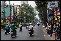 Motorbike traffic and pedestrians waiting for bus. Ho Chi Minh City, Vietnam (color)