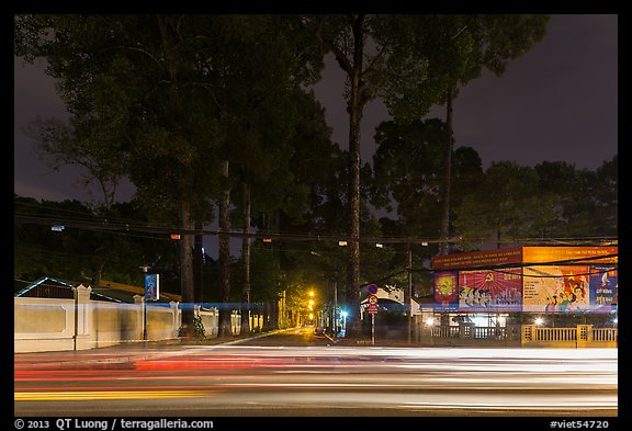 Traffic light trails and tall trees next to Van Hoa Park. Ho Chi Minh City, Vietnam (color)