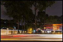 Traffic light trails and tall trees next to Van Hoa Park. Ho Chi Minh City, Vietnam (color)