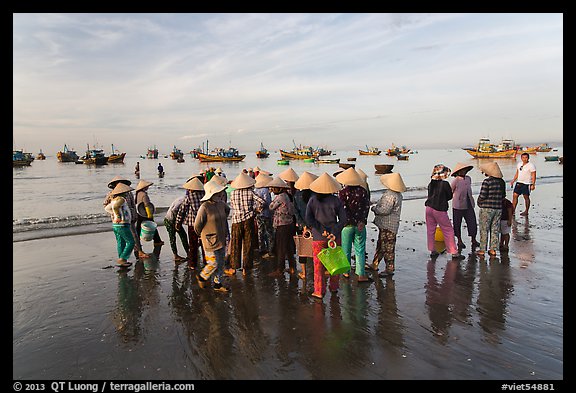 Women gather on beach to collect freshly caught fish. Mui Ne, Vietnam (color)
