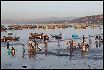 Hawkers gather on mirror-like beach in early morning. Mui Ne, Vietnam (color)