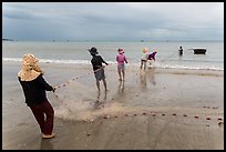 Fishermen lining up to pull net onto beach. Mui Ne, Vietnam (color)