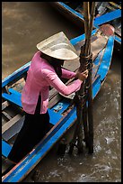 Woman in Ao Ba Ba holding from boat to bamboo poles. My Tho, Vietnam (color)