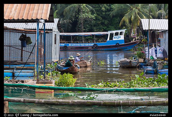 Men fishing next to houseboats. My Tho, Vietnam