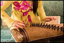 Close up of hands playing plucked zither. My Tho, Vietnam (color)