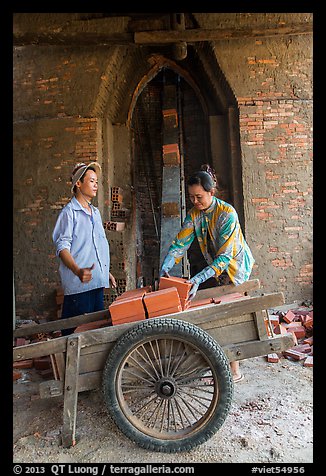 Workers loading bricks out of brick oven. Mekong Delta, Vietnam (color)