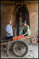 Workers loading bricks out of brick oven. Mekong Delta, Vietnam (color)